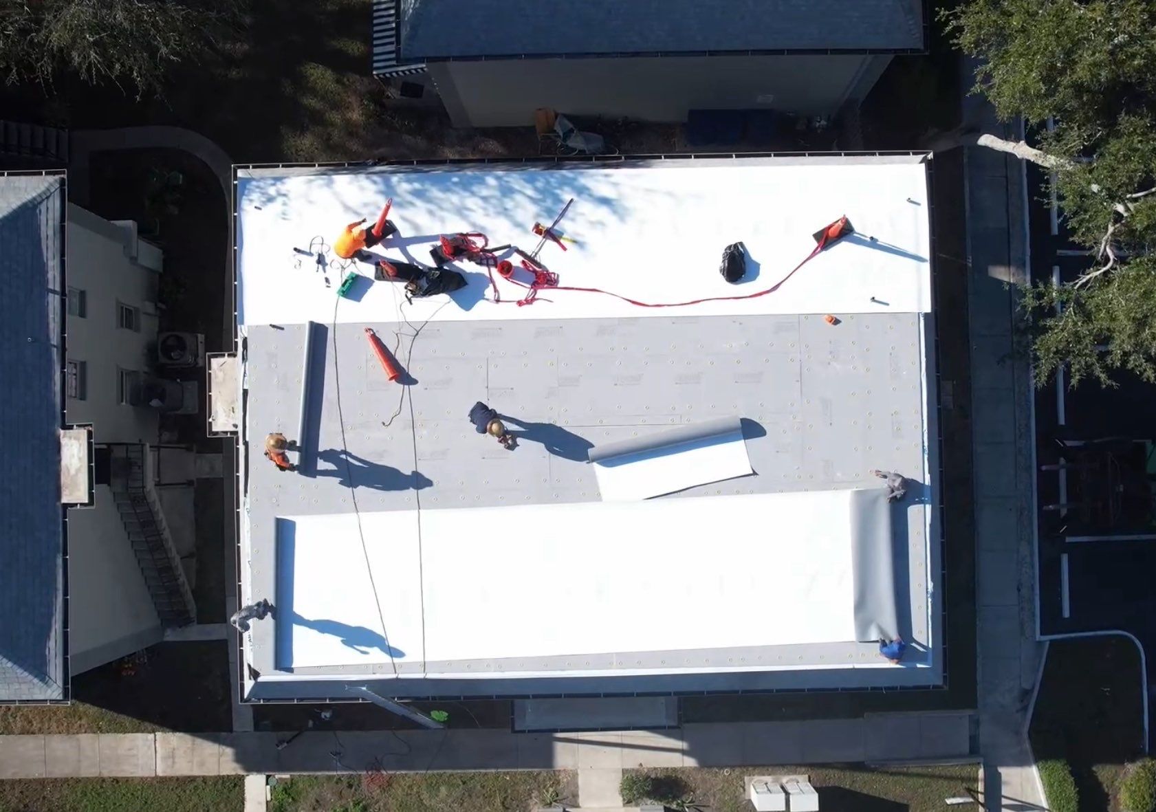 Les Chateaux aerial — TPO membrane and shingle installation